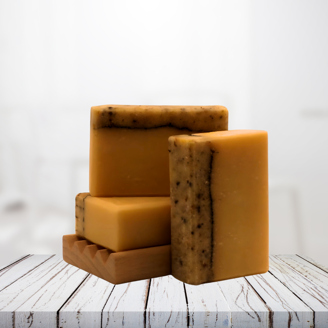 Natural soap bars with calendula blossoms on a wooden dish.