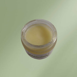 Chamomile cleansing balm jar with creamy texture and natural ingredients on wooden surface