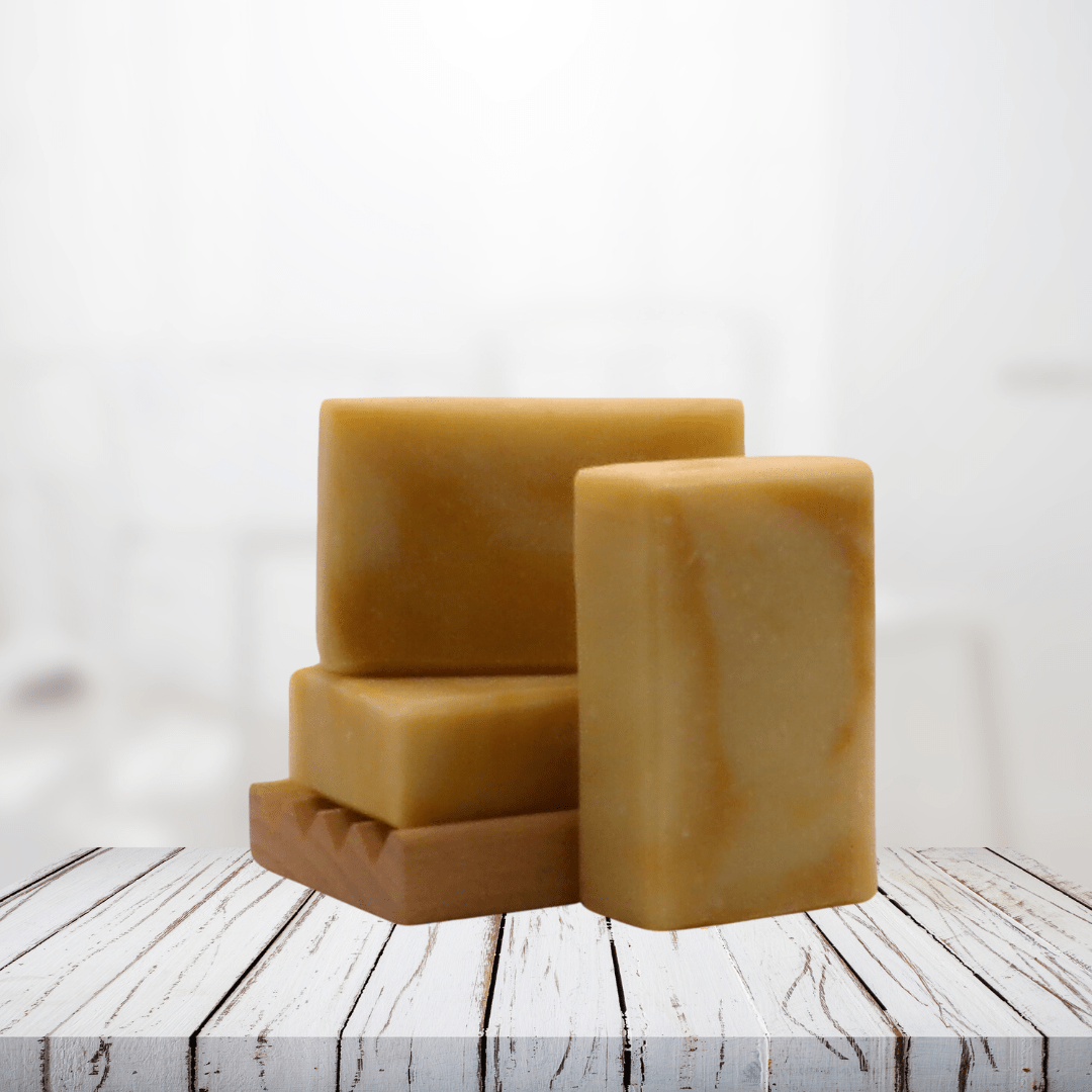 Natural soap bars with dandelion infusion on white rustic wooden surface.