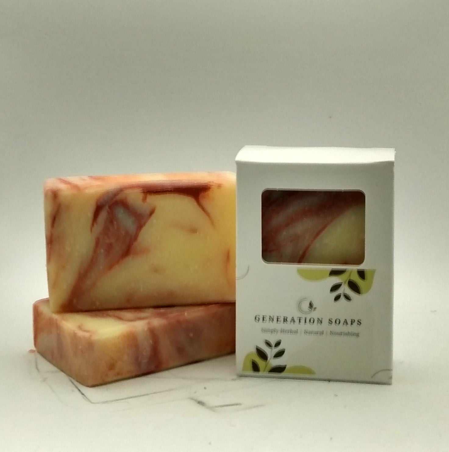 Natural soap bars with pink grapefruit and eucalyptus, showcasing a marbled design on a wooden soap dish.