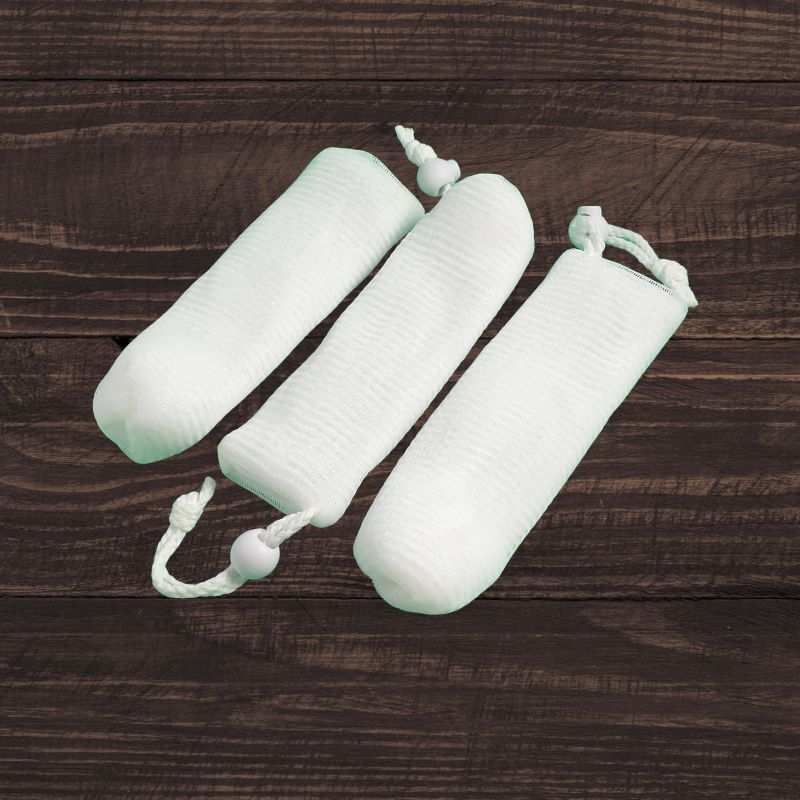 Mesh soap saver pouch holding soap bar for exfoliating and longer-lasting use in shower