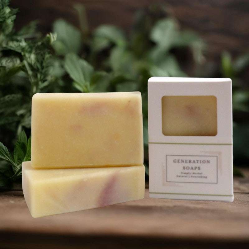 natural soap made with lavender and bergamot essential oils in a white box on a wood shelf with leaves in background